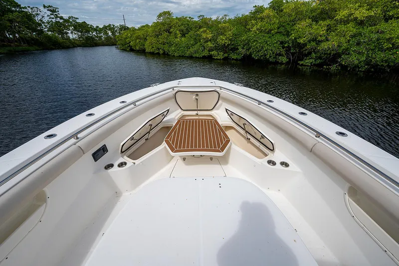 Slide: The Image of 2017 Boston Whaler 370 Outrage boat on a serene river with lush greenery. - 48