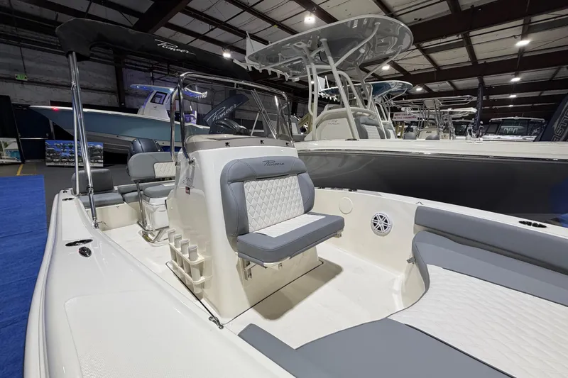 Slide: The Image of 2026 Pioneer 180 Islander boat interior with seating and console, displayed indoors. - 6