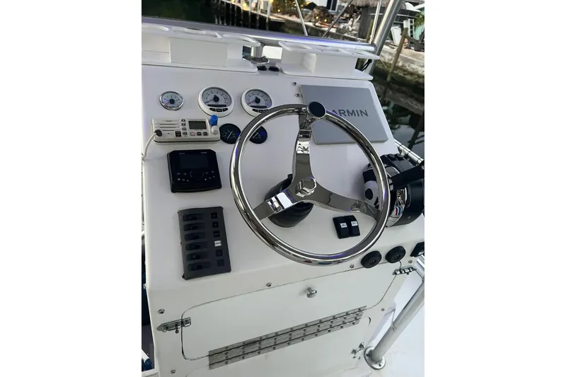 Slide: The Image of 2010 A&M Manufacturing Triton Pontoon dashboard with steering wheel and gauges. - 3