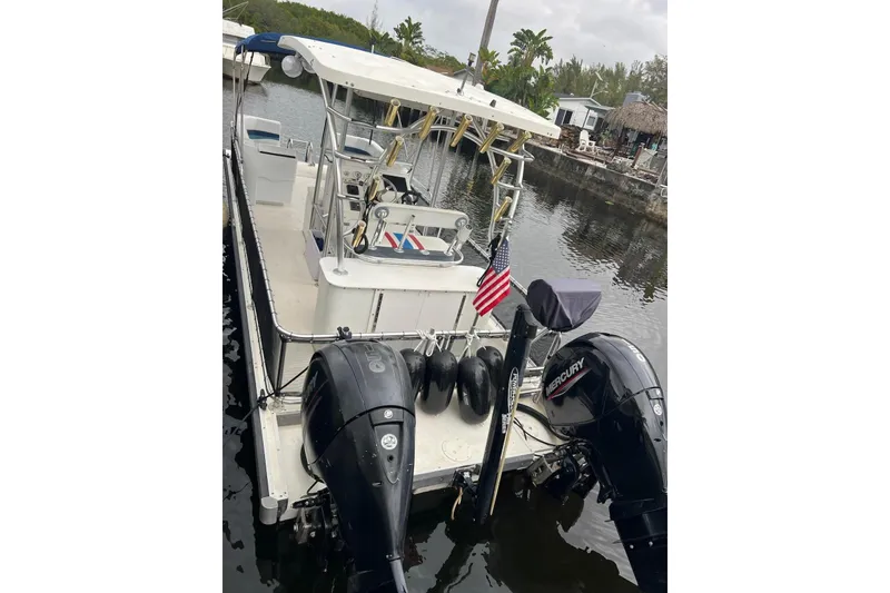 Slide: The Image of 2010 A&M Manufacturing Triton Pontoon with dual Mercury outboard motors docked on a calm waterway. - 6