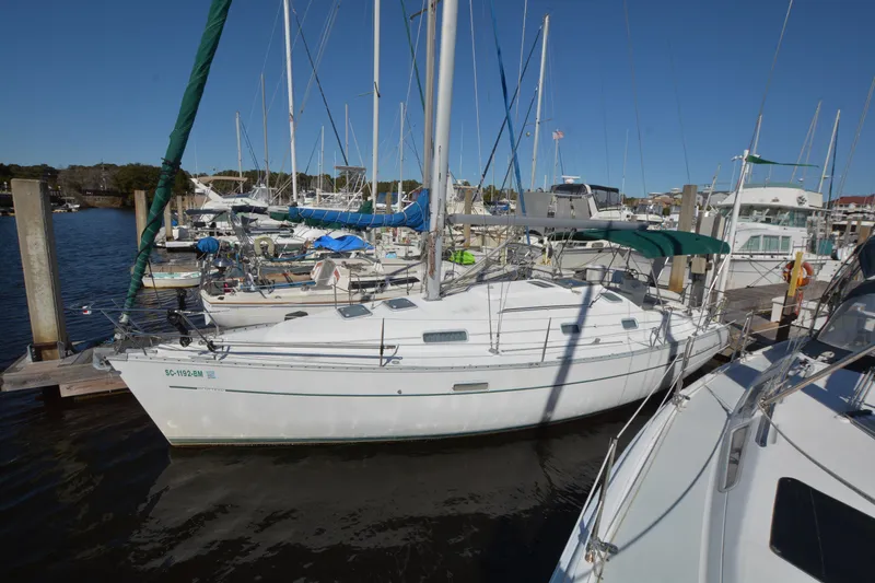 Slide: The Image of 2002 Beneteau Oceanis 331 sailboat docked at marina under clear blue sky. - 2