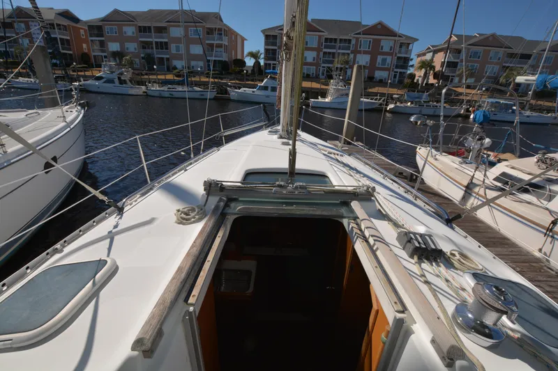 Slide: The Image of 2002 Beneteau Oceanis 331 sailboat docked at marina with residential buildings in background. - 14