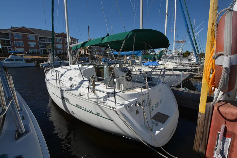 Slide: The Image of 2002 Beneteau Oceanis 331 sailboat docked at marina, green canopy, clear sky. - 3