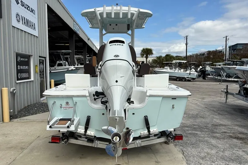 Slide: The Image of 2026 Sea Pro 230 Bay boat with outboard motor at dealership, featuring Suzuki and Yamaha signage. - 13