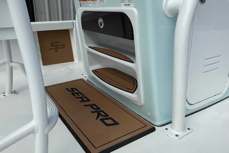 Slide: The Image of 2026 Sea Pro 230 Bay boat interior with branded mat and storage compartments. - 16