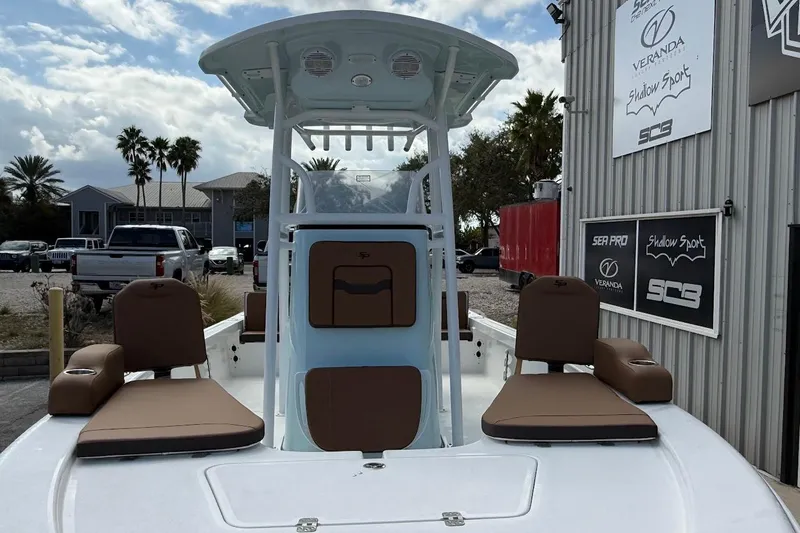 Slide: The Image of 2026 Sea Pro 230 Bay boat with brown seating, docked near a building. - 3