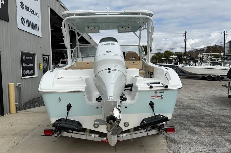 Slide: The Image of 2026 Sea Pro 240 Dual Console boat with powerful outboard motor, parked at a dealership. - 8