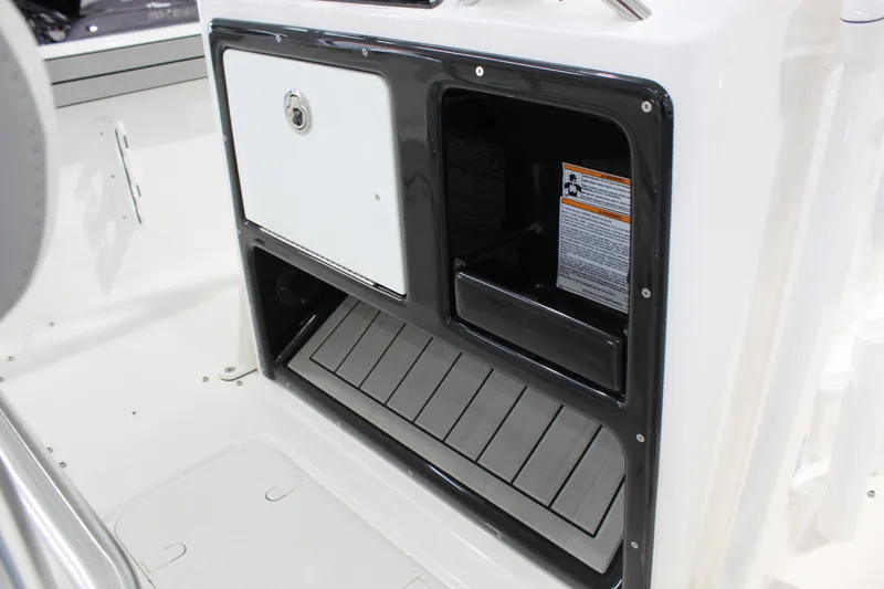 Slide: The Image of 2026 Yamaha Boats 195 FSH Sport storage compartment with secure latch and open space. - 7