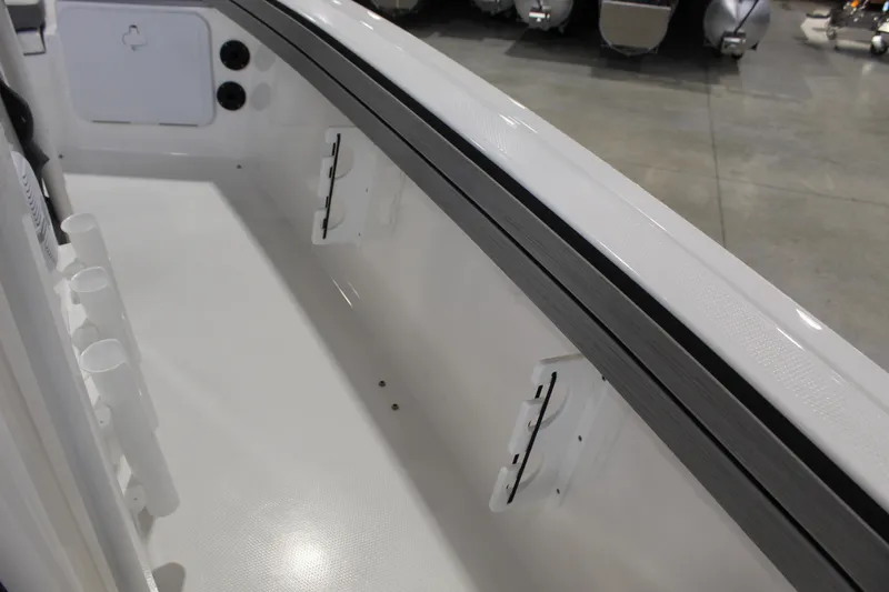 Slide: The Image of 2026 Yamaha Boats 195 FSH Sport interior detail, showcasing storage and rod holders. - 9