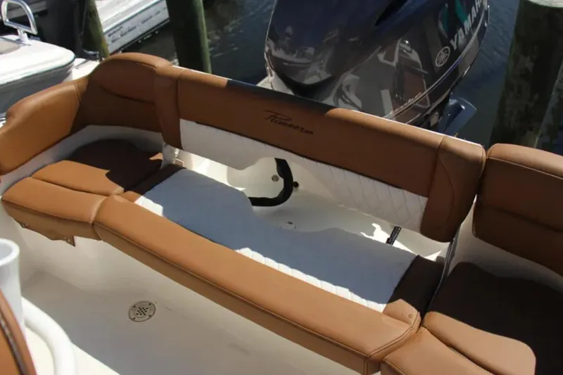 Slide: The Image of 2026 Pioneer 202 Islander boat with brown and white seating, docked near Yamaha engine. - 12