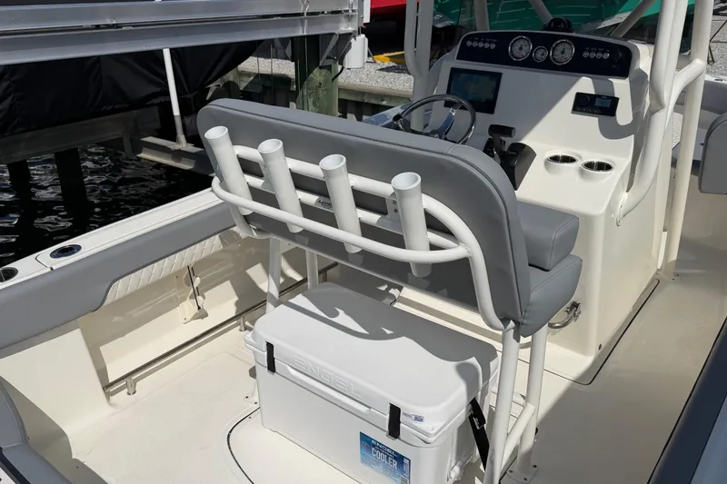 Slide: The Image of 2026 Pioneer 202 Islander boat interior with helm, rod holders, and cooler. - 20