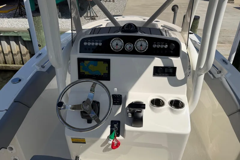 Slide: The Image of 2026 Pioneer 202 Islander boat dashboard with steering wheel, gauges, and navigation screen. - 21