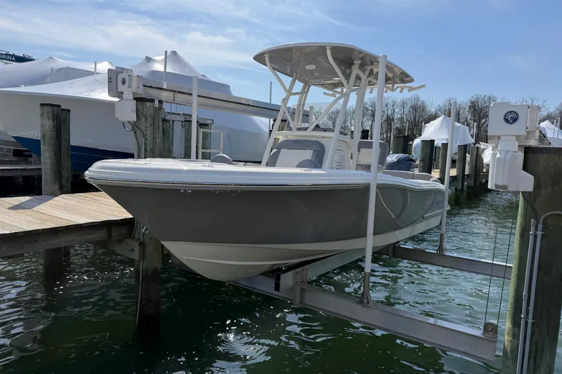 Slide: The Image of 2026 Pioneer 202 Islander boat docked on a lift at a marina. - 23