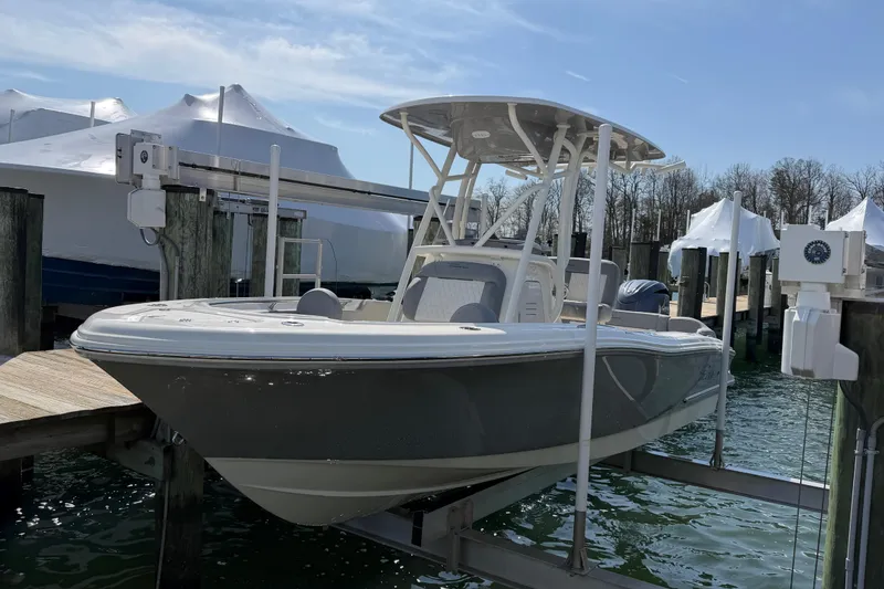 Slide: The Image of 2026 Pioneer 202 Islander boat on lift at marina, clear sky background. - 25