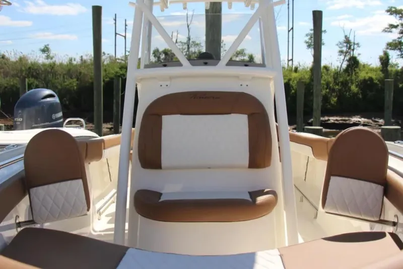 Slide: The Image of 2026 Pioneer 202 Islander boat interior with brown and white seating, docked outdoors. - 7