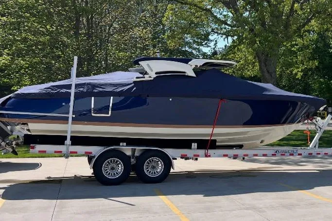 Slide: The Image of 2025 Chris-Craft Launch 28 GT boat on trailer, covered, parked outdoors. - 2