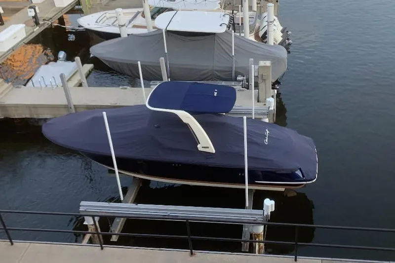 Slide: The Image of 2025 Chris-Craft Launch 28 GT boat docked with cover on water. - 45