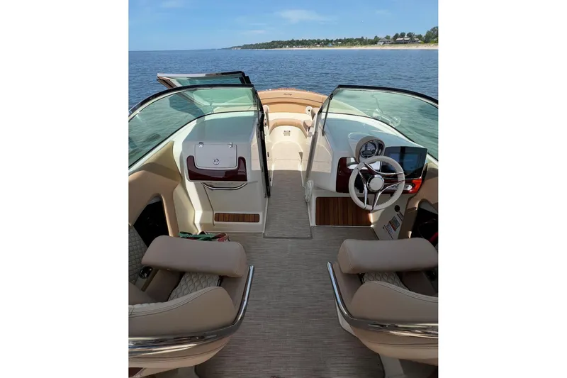 Slide: The Image of 2025 Chris-Craft Launch 28 GT interior with luxurious seating and modern dashboard on open water. - 8