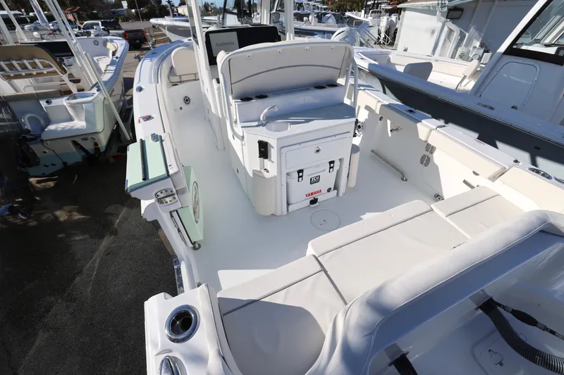 Slide: The Image of 2026 Sea Hunt Ultra 265 SE boat interior with seating and console, docked at marina. - 2