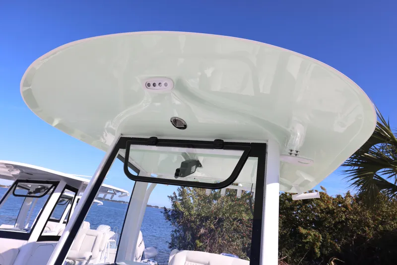 Slide: The Image of 2026 Sea Hunt Ultra 265 SE boat with sleek T-top design against clear blue sky. - 27