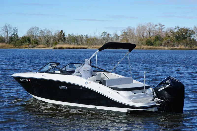Slide: The Image of 2025 Searay SPX210 boat on a calm lake with trees in the background. - 5