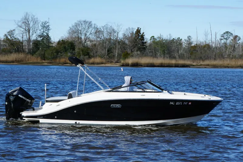 Slide: The Image of 2025 Searay SPX210 boat on calm water, featuring sleek black and white design. - 6