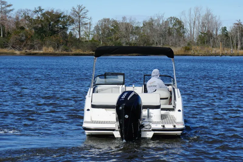 Slide: The Image of 2025 Searay SPX210 boat cruising on a serene lake with trees in the background. - 8