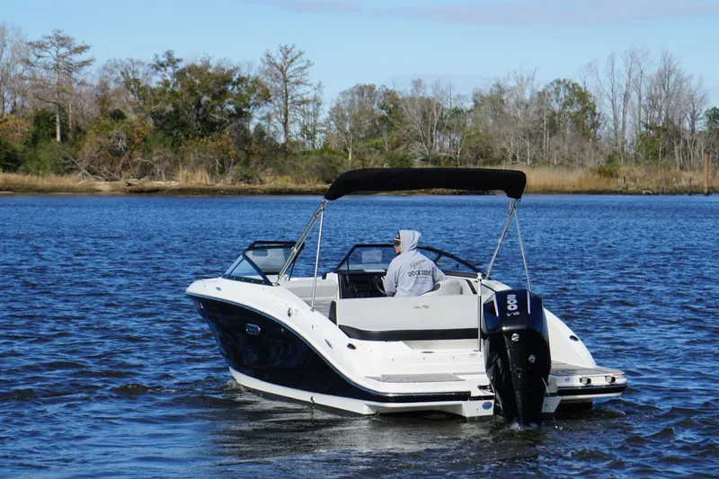 Slide: The Image of 2025 Searay SPX210 boat cruising on a serene lake with trees in the background. - 9