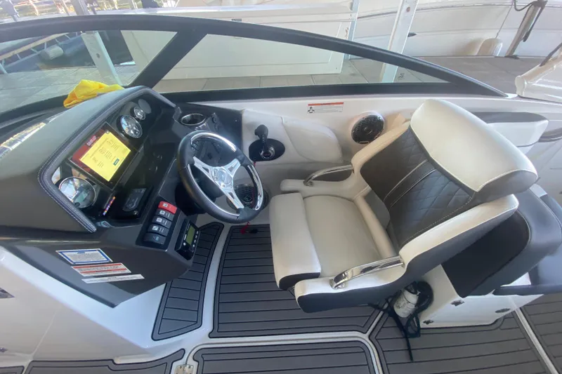 Slide: The Image of 2022 Monterey M-65 boat cockpit with steering wheel, dashboard, and cushioned seat. - 15