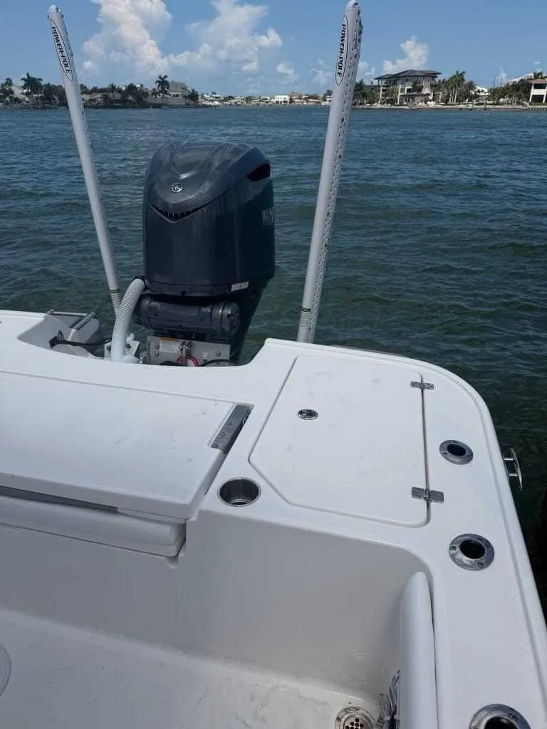 Slide: The Image of The image shows the stern of a Caymas 26 HB boat with an outboard motor on calm water. - 15