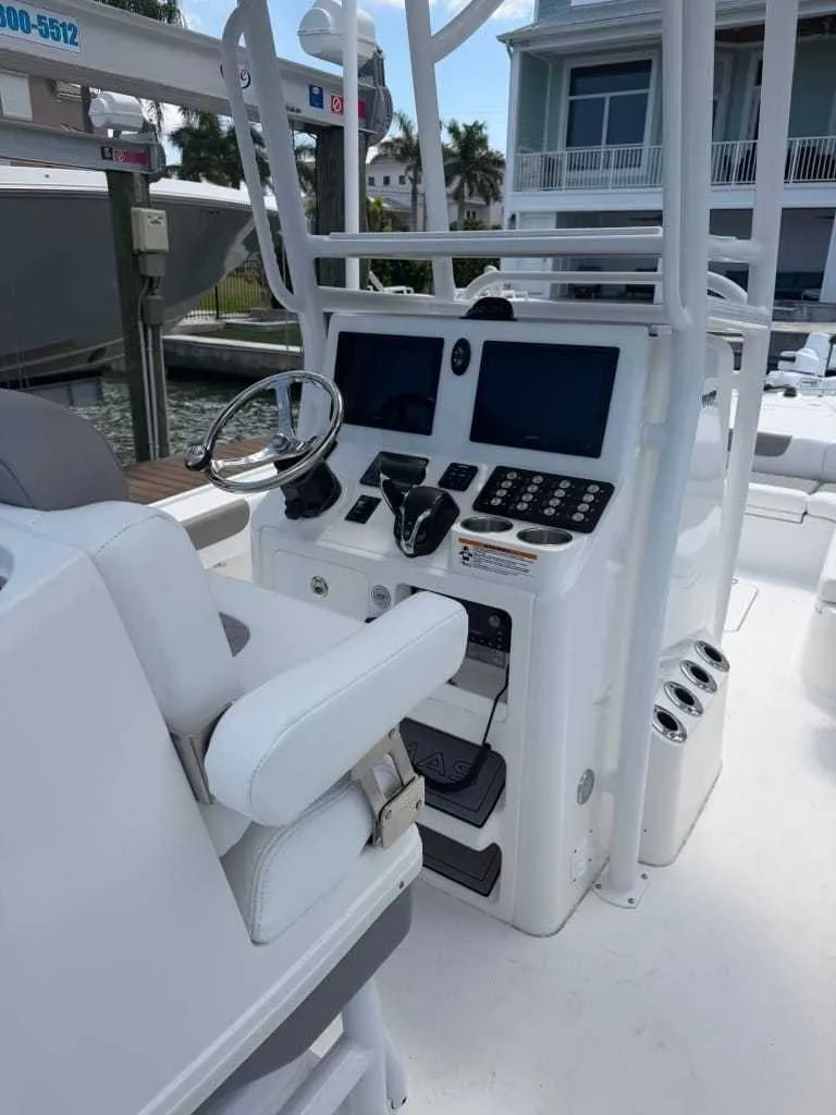 Slide: The Image of The image shows the helm of a Caymas 26 HB boat with modern instruments and a white seat. - 11