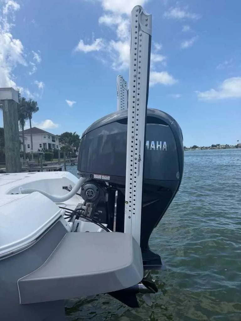 Slide: The Image of A 2026 Caymas 26 HB boat with a Yamaha outboard motor, in the water near a dock. - 16