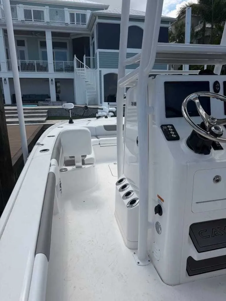 Slide: The Image of The image shows a modern boat with a white helm and sleek details, docked by a house. - 6
