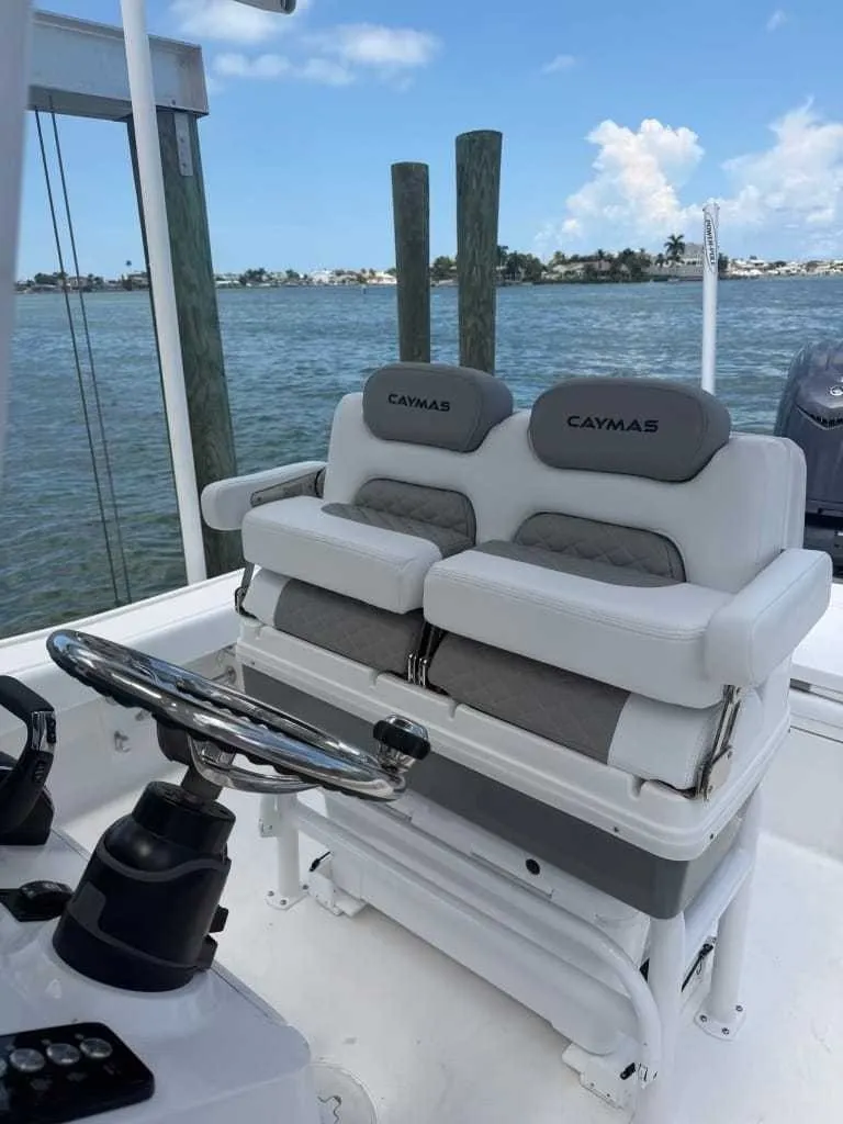 Slide: The Image of The image shows the cockpit of a Caymas 26 HB boat with cushioned seats and a steering wheel. - 12