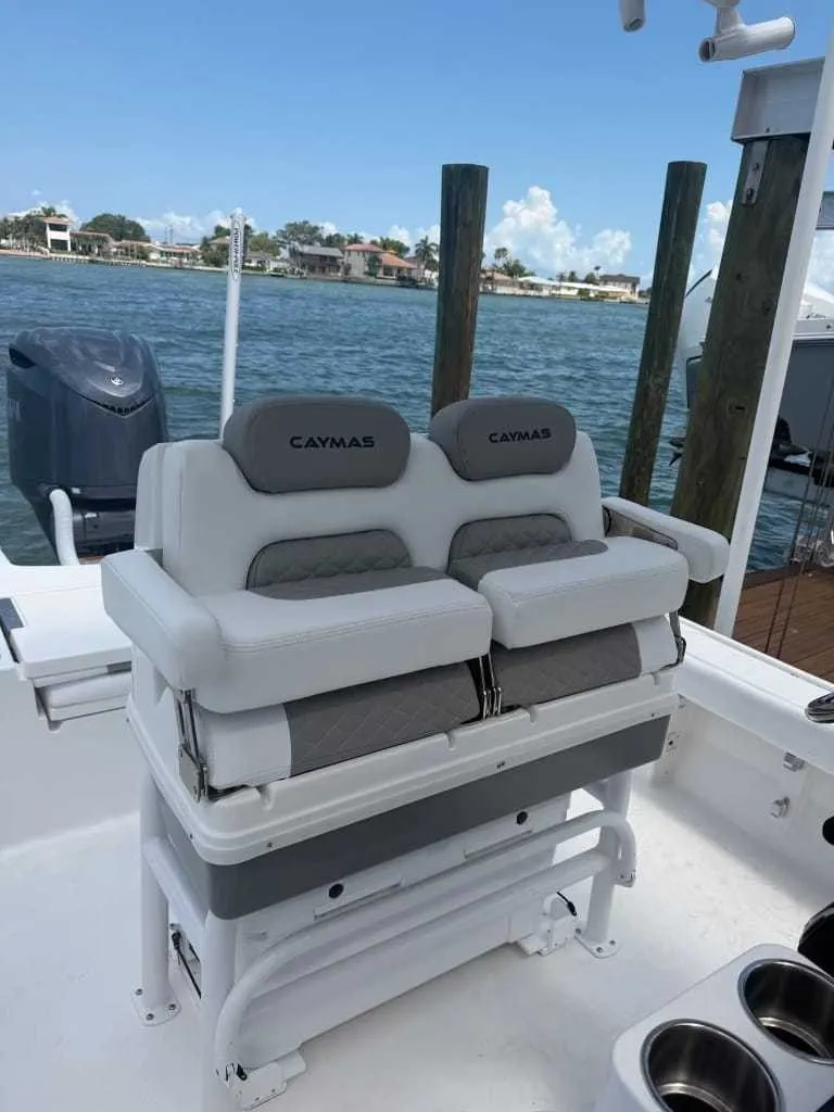 Slide: The Image of The image shows the seating of a 2026 Caymas 26 HB boat, featuring gray upholstery and an engine in the background. - 9
