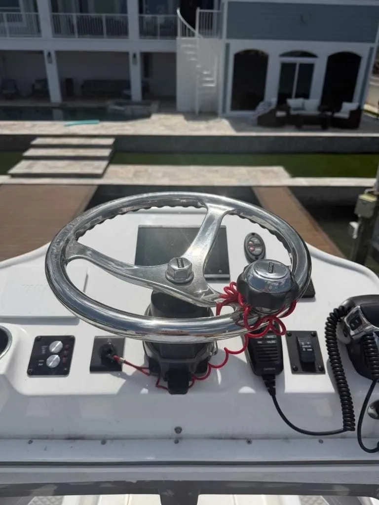Slide: The Image of The image shows the helm of a Caymas 26 HB boat. It is situated in a modern marina. - 13