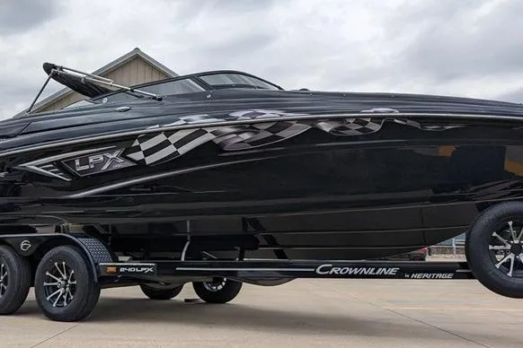The Image of 2024 Crownline 240 SS LPX boat on trailer, sleek black design with checkered graphics. - 1