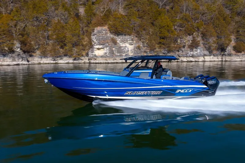 Slide: The Image of 2026 Sunsation 34 CCX speedboat cruising on a calm lake with scenic background. - 36