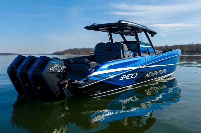 Slide: The Image of 2026 Sunsation 34 CCX boat with triple outboard engines on a calm lake. - 39