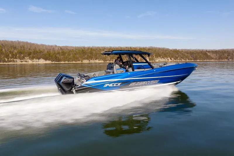 Slide: The Image of 2026 Sunsation 34 CCX speedboat cruising on a calm lake under a clear sky. - 41