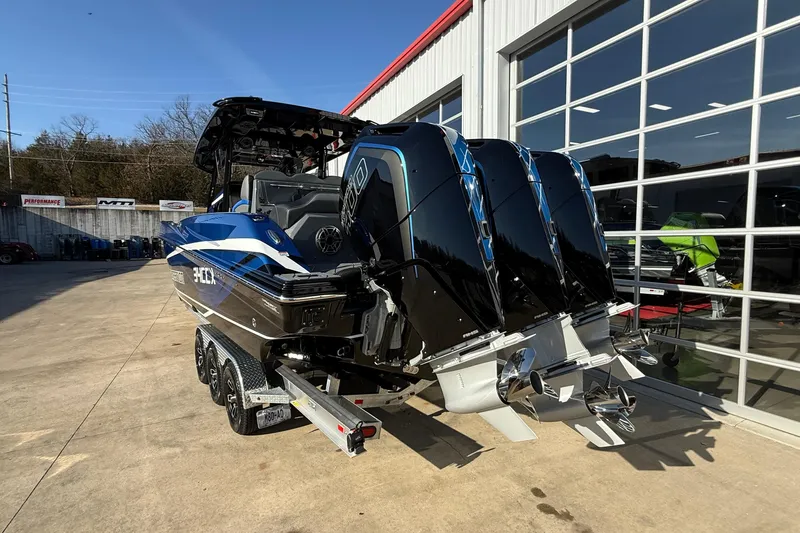 Slide: The Image of 2026 Sunsation 34 CCX boat with triple engines, parked outside a showroom. - 6