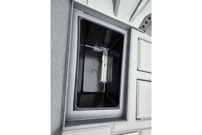 Slide: The Image of 2026 Xpress H17C Crappie boat storage compartment with a small item inside. - 12