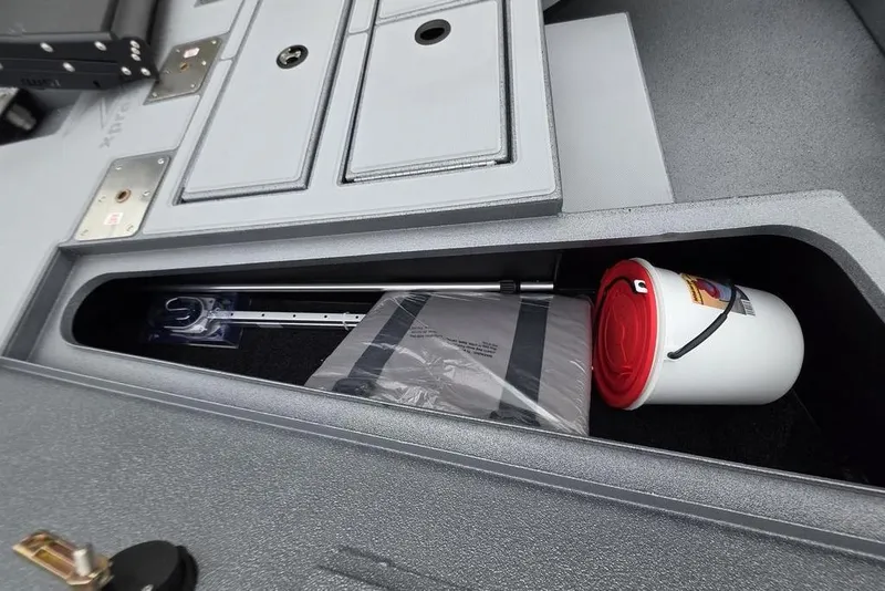 Slide: The Image of Storage compartment of 2026 Xpress H17C Crappie boat with fishing gear and bucket. - 15