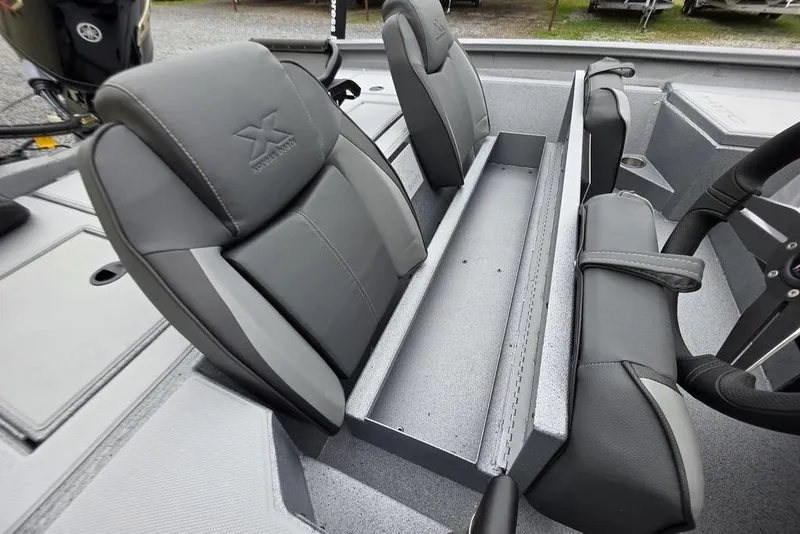 Slide: The Image of 2026 Xpress H17C Crappie boat interior with gray seating and steering wheel. - 18