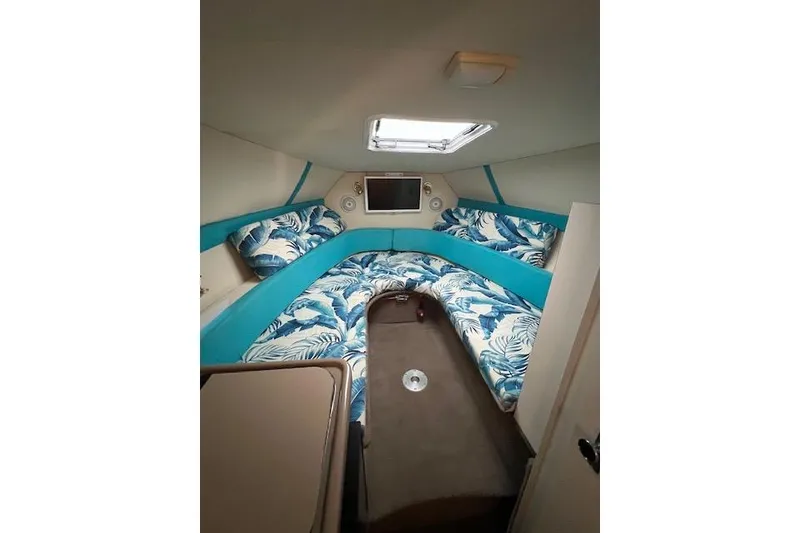 Slide: The Image of 2003 Glastron GS 279 cabin interior with tropical-themed bedding and skylight. - 3