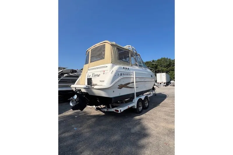 Slide: The Image of 2003 Glastron GS 279 boat on trailer, parked outdoors under clear blue sky. - 4