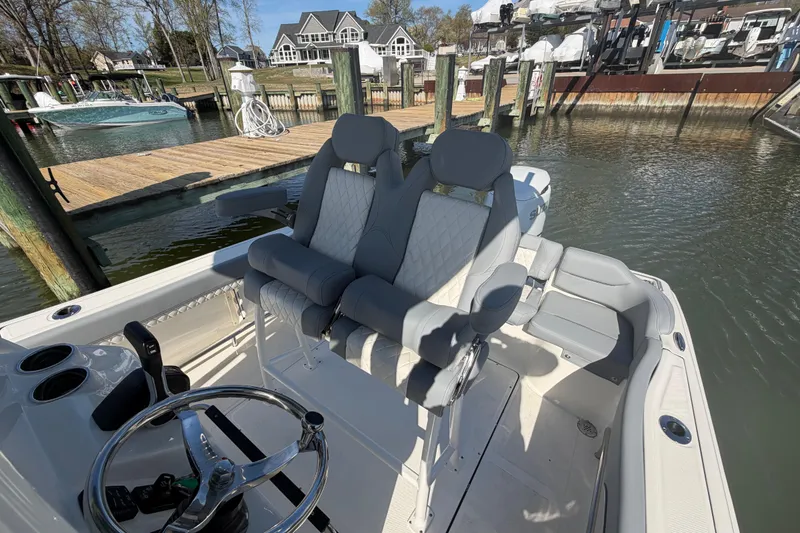 Slide: The Image of 2026 Pioneer 222 Islander boat interior with dual seats at a marina dock. - 12