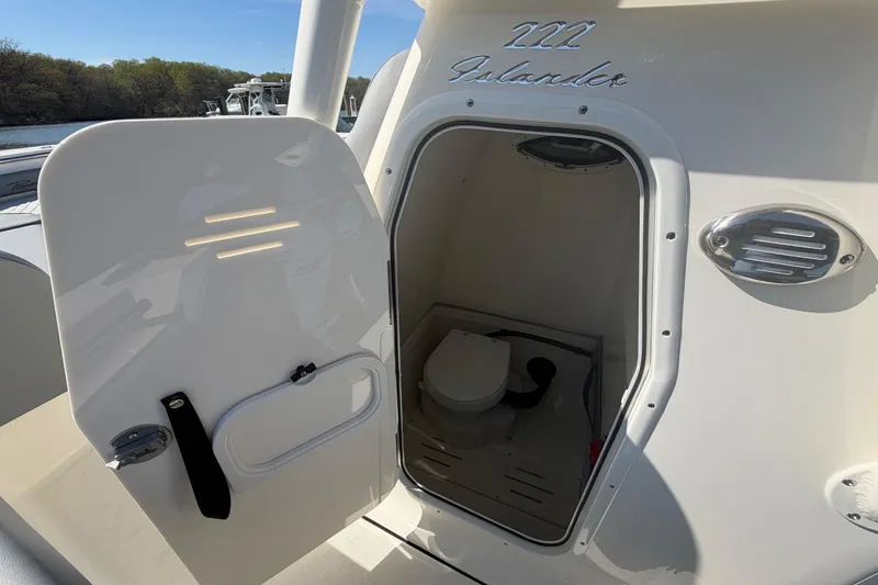 Slide: The Image of 2026 Pioneer 222 Islander boat with open cabin door revealing interior amenities. - 13