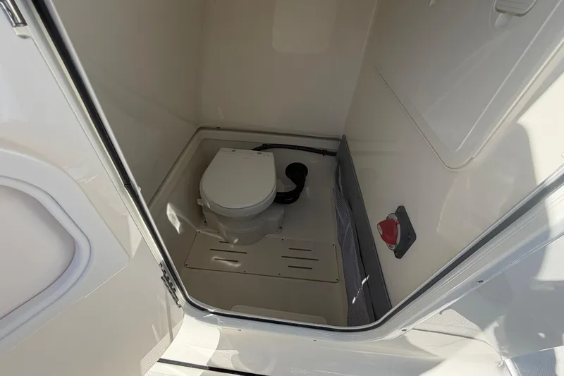Slide: The Image of Interior of 2026 Pioneer 222 Islander boat bathroom with compact toilet. - 14