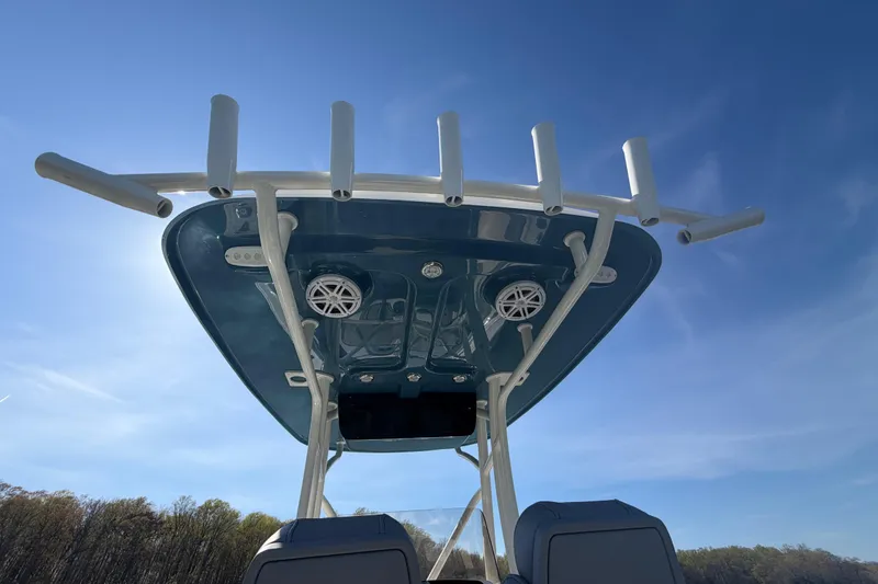 Slide: The Image of 2026 Pioneer 222 Islander boat with rod holders and speakers under a clear blue sky. - 15